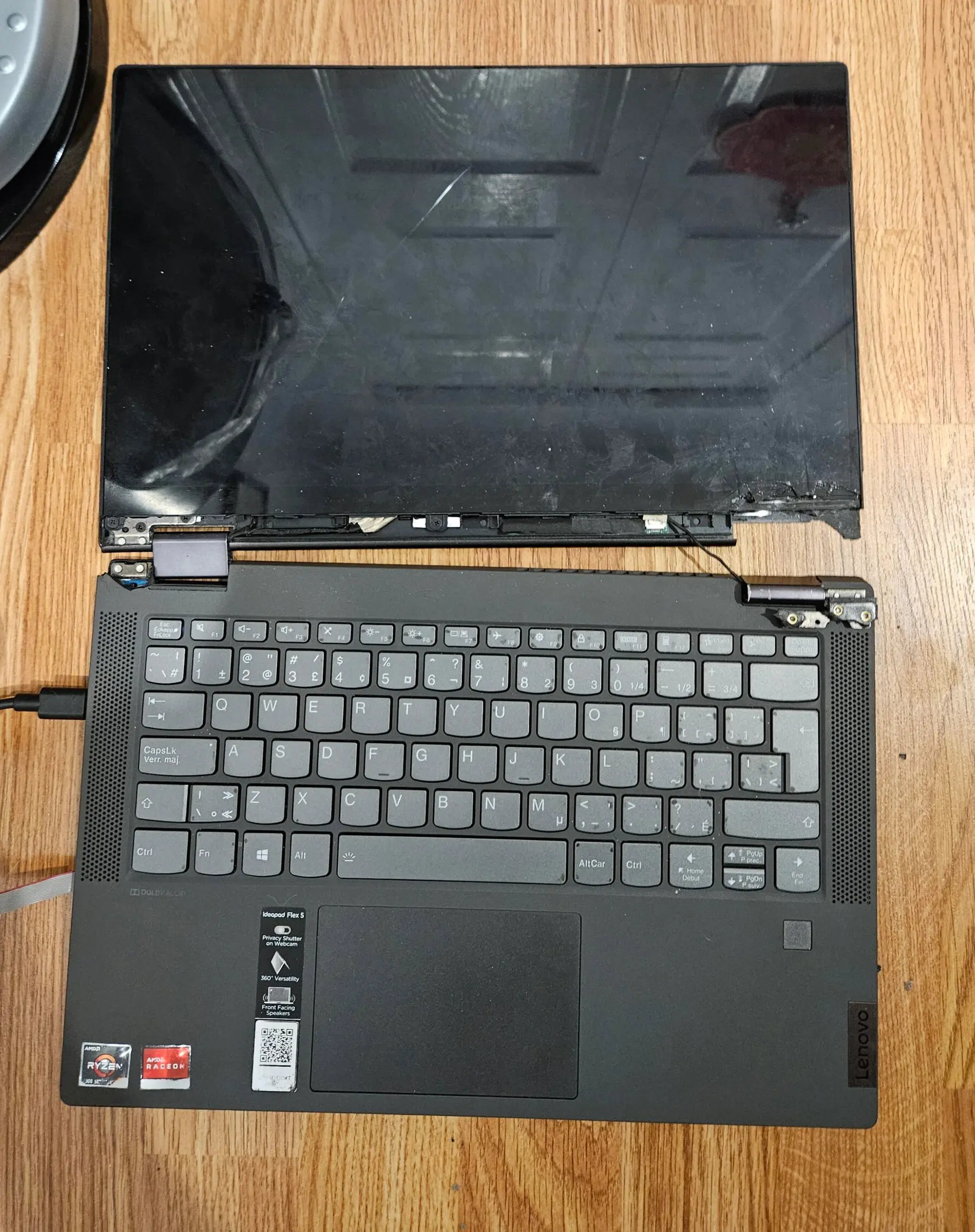The laptop under heavy physical damage with the screen almost detached.